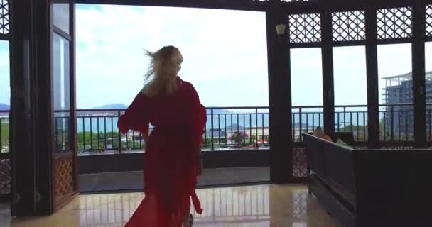 Mujer vestida de rojo saliendo de la habitación de hotel — Vídeos de Stock