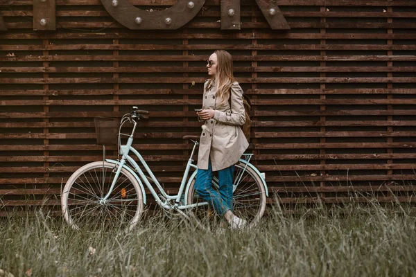 Schönes Mädchen, das neben ihrem modischen Fahrrad steht — Stockfoto
