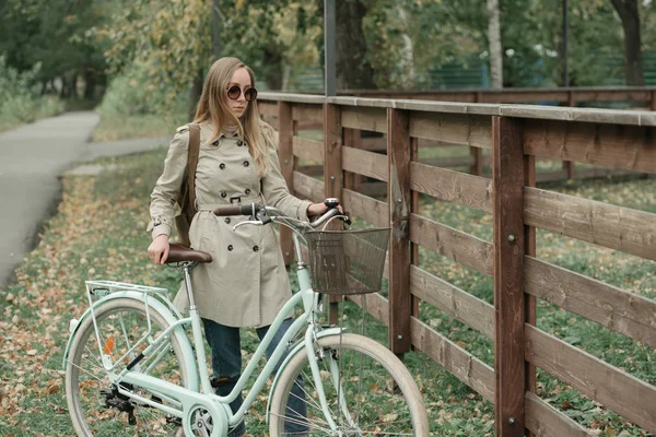 Mädchen parkt ihr Fahrrad im Herbstpark — Stockfoto