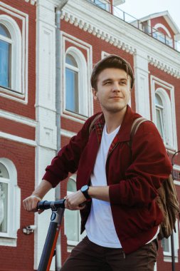 Eski binaların önünde gülümseyen vintage şapka genç hipster