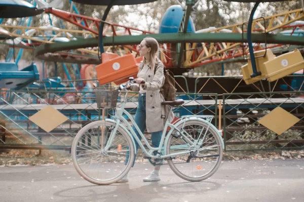 Schöne junge Frau mit Fahrrad im Park — Stockfoto