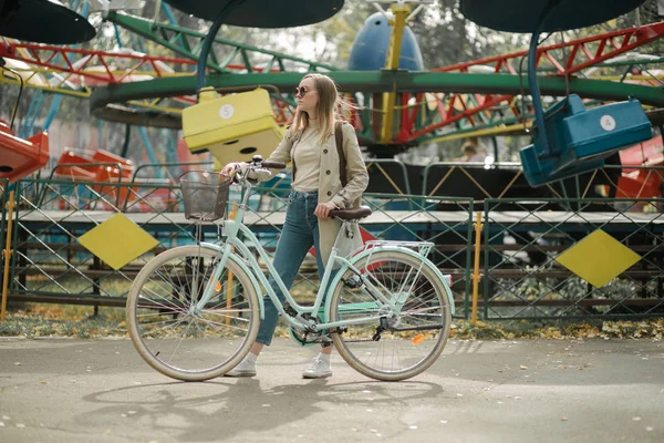 Schöne junge Frau mit Fahrrad im Park an einem Frühlingstag — Stockfoto