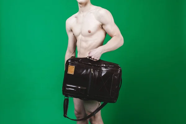 Athletic man with leather bag in studio
