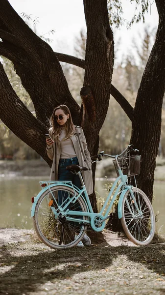 Dziewczyna w okularach przeciwsłonecznych z rowerem pod drzewem — Zdjęcie stockowe