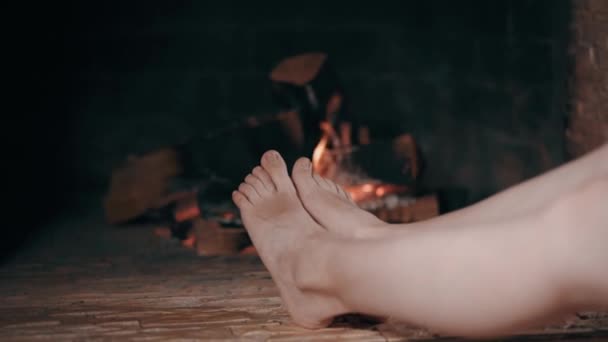 Närbild av kvinnors fötter vid öppna spisen — Stockvideo