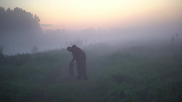 男遊びともに彼の美しい黄金の取得犬近くの霧の川. — ストック動画