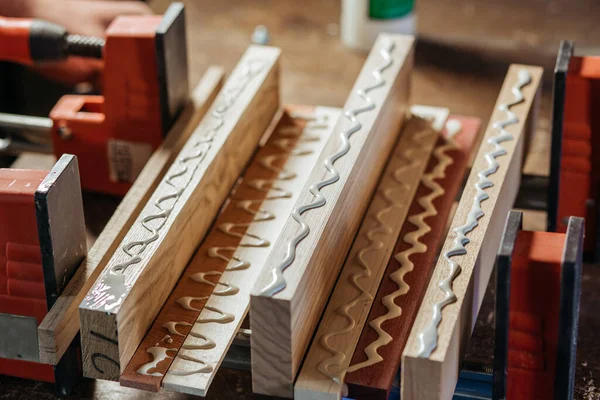 Bonding wood in the workshop. The use of glue for different types of wood. Making worktops for the kitchen. Work as a craftsman. Creating a cutting board design