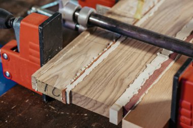 Atölyede ahşap bağlanıyor. Farklı ahşap türleri için zamk kullanımı. Mutfak için atölye hazırlıyorum. Bir zanaatkar olarak çalış. Bir kesme tahtası dizaynı oluşturuluyor