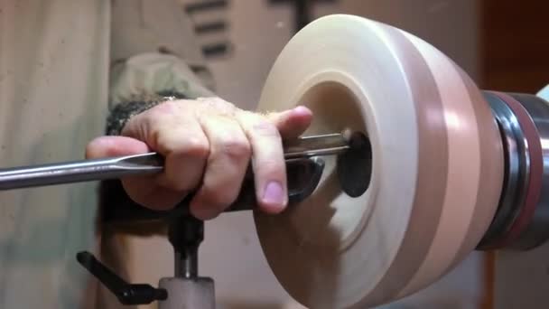 Craftsman works with workpiece in authentic workshop. Woodworker handles wood by bench. Making beautiful wooden handmade dish. Creation of unusual plate. Carpenter cuts wood by graver in soft focus — Stock Video