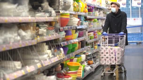 Mężczyzna w rękawiczkach ochronnych kupuje papier toaletowy w sklepie. — Wideo stockowe