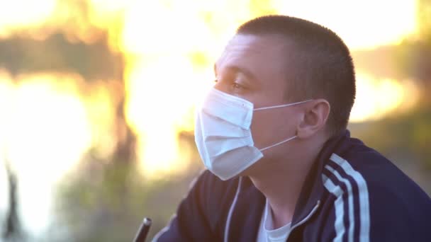 Mężczyzna wypuszcza dym spod maski medycznej na twarz. — Wideo stockowe