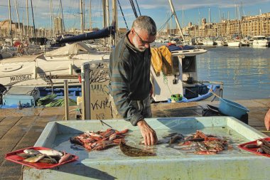 Fransa, Marsilya - 19 Kasım 2018: Marsilya 'daki balık pazarında alıcı. Eski Marsilya Limanı (Vieux-Port), Fransa 'nın Akdeniz kıyısındaki en büyük şehri ve en büyük ticari limanıdır. 19 Ekim 2018.