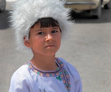 Ashgabat, Türkmenistan - 12 Eylül 2017. Kimliği belirsiz ciddi bir Asyalı çocuğun portresi. Geleneksel ulusal giysili çocuk.