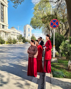 Ashgabad, Türkmenistan - 26 Mart 2025. Ulusal giyinmiş bir grup öğrenci açık havada. Ashgabad, Türkmenistan - 26 Mart 2025