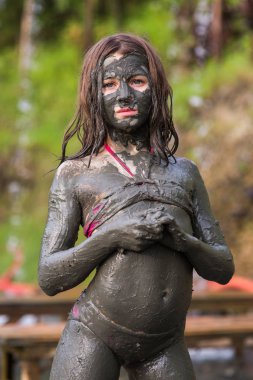 Çamur maskesi tüm vücut üzerinde mayoyla bir kız portresi kapatın