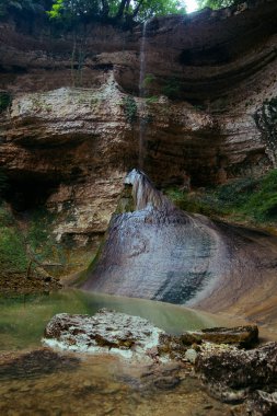 ormanda bir uçurumun üzerinden düşen yüksek şelale