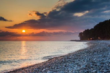 Günbatımında sakin çakıl plajı