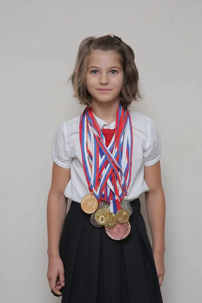 Boynunda bir sürü madalya ile Tekdüzen okulda iki kuyruklu kız öğrenci