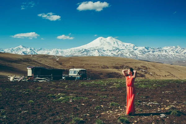 tam büyüme esmere yüksek karla kaplı dağlar arka plan üzerinde kırmızı elbiseli portresi