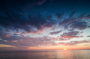 bulutlu gökyüzü okyanusta ufuk çizgisine üzerinde renkli günbatımı
