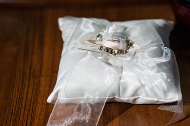 bir çift bir yay ile beyaz bir dekoratif yastık üzerine altın alyans