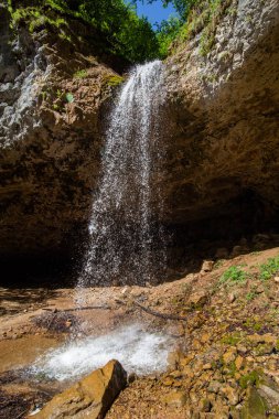güneşli bir günde kayalar taşkın ile güzel yüksek düşen şelale