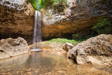 güneşli bir gün whith Mağarası altında sarkan kayalar ile güzel yüksek düşen şelale