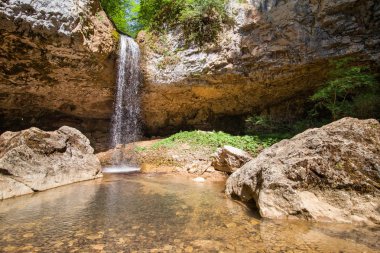 güneşli bir günde kayalar taşkın ile güzel yüksek düşen şelale