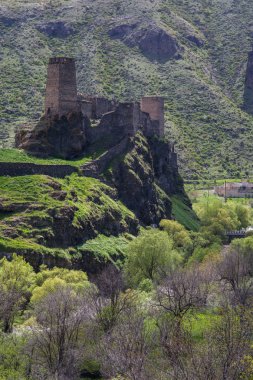 dağlar arasında Gürcistan'da fırtınalı gökyüzü altında bir uçurumun üzerinde ortaçağ kale Khertvisi