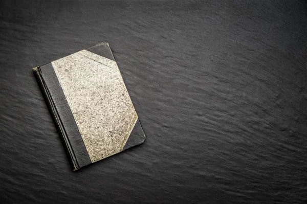 黒い石の背景に古い日記 — ストック写真