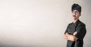 gri arka plan üzerinde gülümseyen bir aşçı