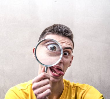 komik bir tabir ile a magnifying cam bakarak bir çocuk