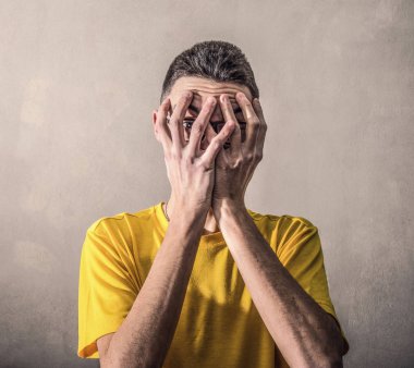 bir çocuk korkuyor ve ellerini yüzüne koyar