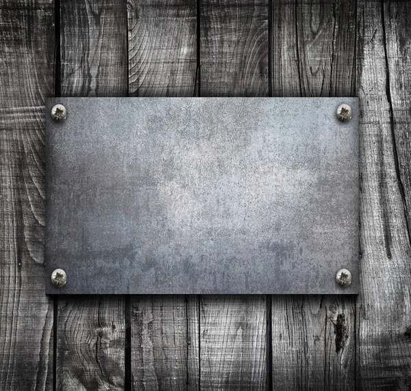 Placa de metal industrial sobre un fondo de madera — Foto de Stock