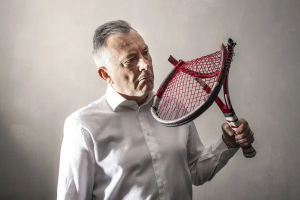 彼の壊れたテニスラケットを見て落胆した男 — ストック写真