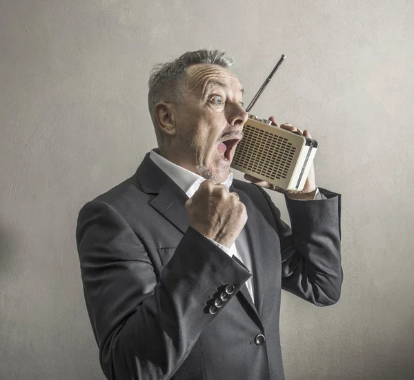 Επιχειρηματίας ακούγοντας ραδιόφωνο κάνοντας παράξενες εκφράσεις — Φωτογραφία Αρχείου