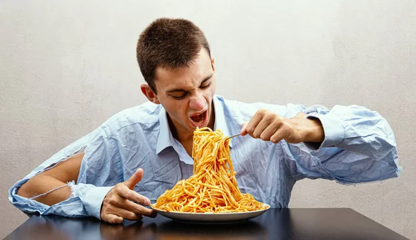 Młody Człowiek Jedzący Spaghetti Sosem Pomidorowym — Zdjęcie stockowe