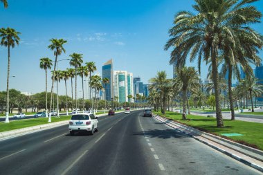 Doha, Katar - 4 Ağustos 2018: Doha modern şehir palmiye ağacı, arabalar, Doha Şehir mavi gökyüzünde üzerinde geniş caddeleri ile.