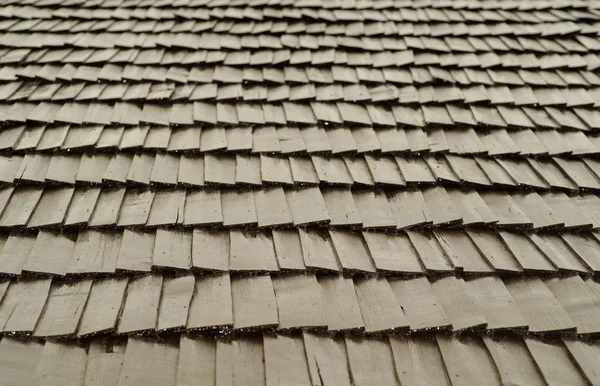 Wooden tile on the roof of the house. Wooden shingles.