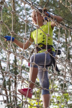 Kız ip parkta engelleri geçmek, kız tırmanmaya road.rope park.