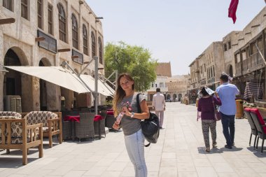 Doha, Katar-04.08.2018. Souq Waqif Al Wakra, Wakra pazarda. East.Doha, Katar Doha, Katar, orta-04.08.2018. Souq Waqif Al Wakra, Wakra pazarda. Doha, Katar, orta East.A kız Avrupa görünüm c içinde belgili tanımlık çarşı yürür