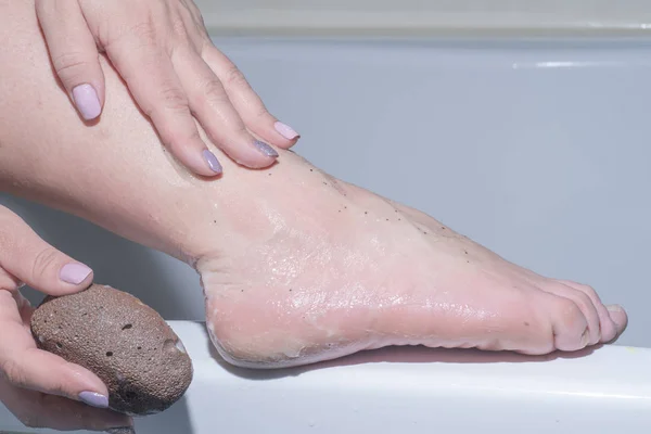 woman having her foot scrubbed  by brush