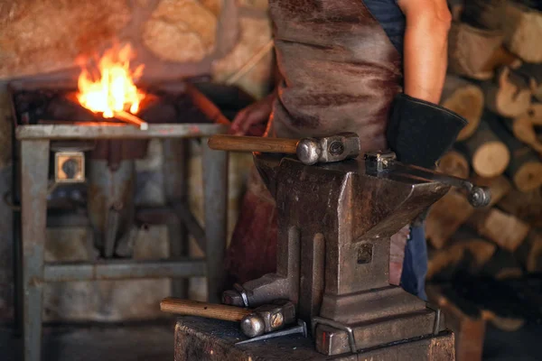 一个穿着工作服的人使用金属 一个人手里拿着锤子和热金属 一个在工作的人 — 图库照片