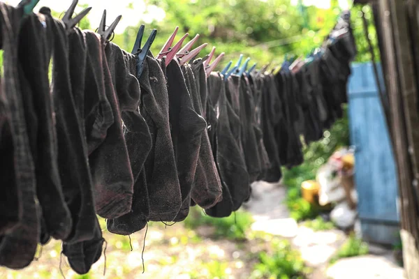 The washed socks are hung on the rope. Dry socks are dried on the street.Hanging clothes drying outdoors.