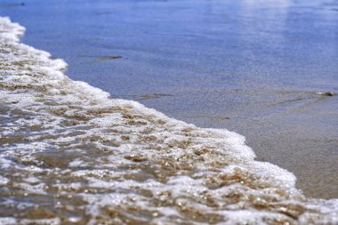 Kumlu sahilde denizin dalga yumuşak. Sandy beach adlı deniz. Kumlu plaj arka plan okyanusta köpükle yumuşak dalgalar.