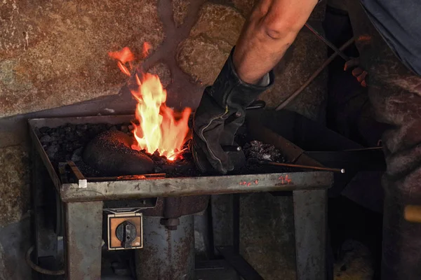 作業服の男は 金属で動作します 彼の手にハンマーと熱い金属を保持します 熱い金属 — ストック写真