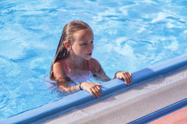 Güzel küçük bir kız havuzda, sevimli küçük kız güneşli day.little kız havuzunda yüzüyor. .