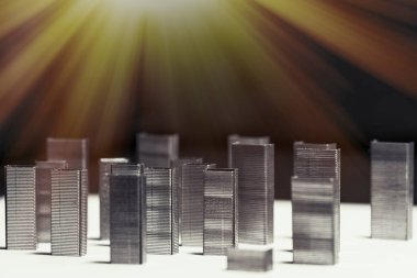 Çok katlı binalar şeklinde metollik zımbaların bileşimi. Yüksek binaların taklidi. Arka plan, seçici odaklanma. Çok katlı binalar şeklinde metollik zımbaların bileşimi.