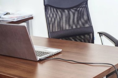 Ofis, ofis masası ve sandalyenin üzerindeki bilgisayar ağa bağlı. Dizüstü bilgisayarlı bir işyeri. .