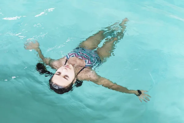 Meisje duik in het zwembad. Gelukkig meisje speelt in de poule. Mooi meisje zwemmen en plezier in het water. Actieve vakantie. — Stockfoto